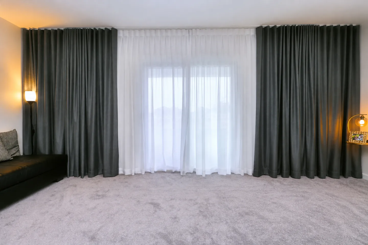 Dark curtains layered with white sheers; bedroom photo edited to remove the bed